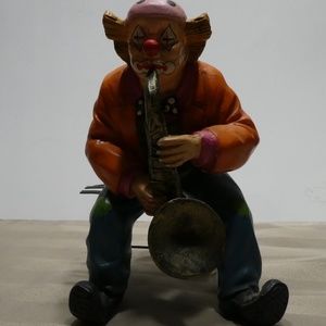 CLOWN porcelain sitting on bench playing saxophone